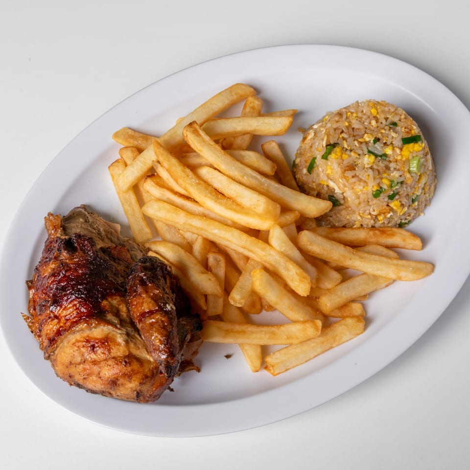 Grilled chicken quarter with crispy french fries and a scoop of fried rice on a white plate.